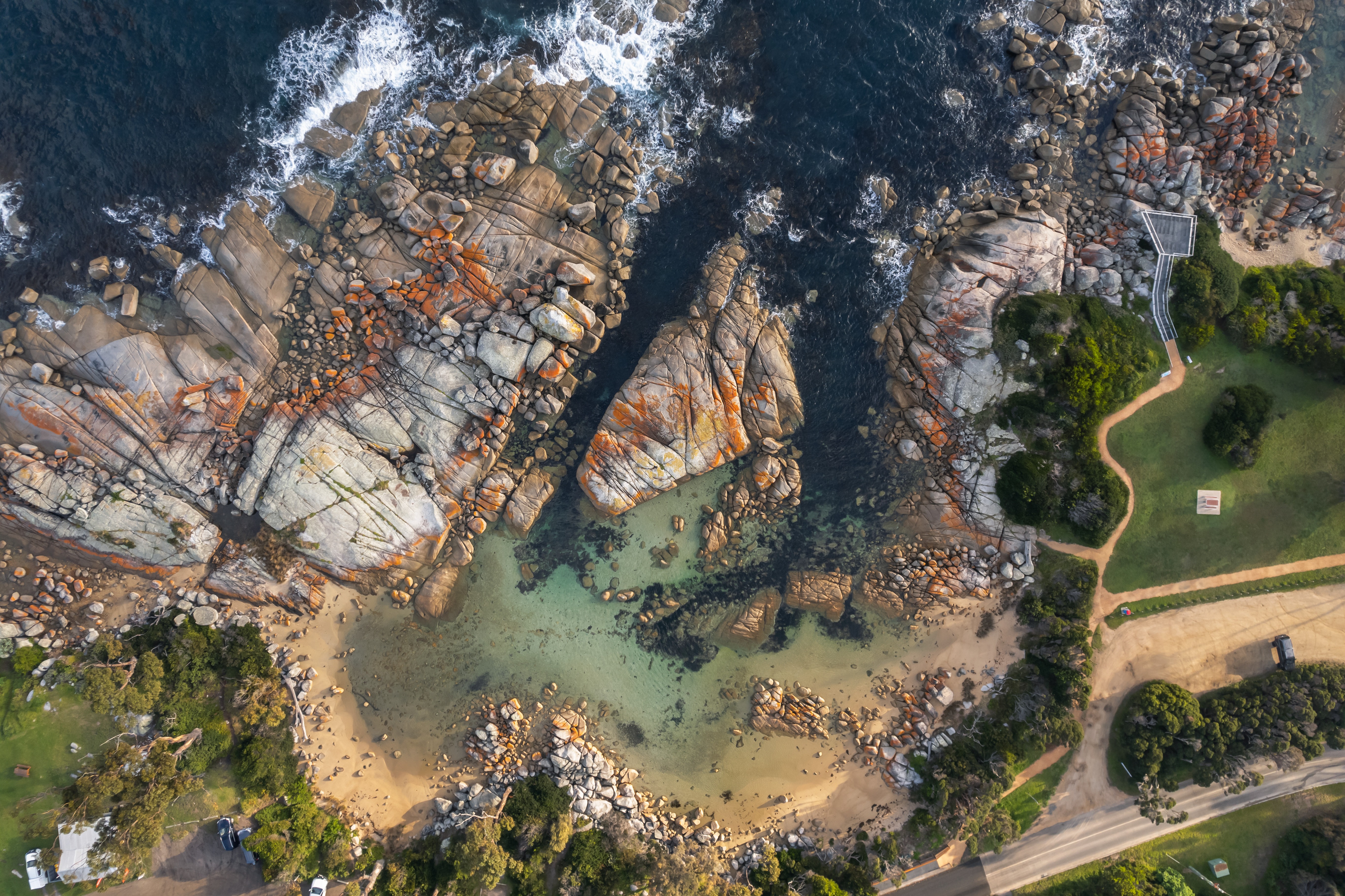 Aerial view of a sandy cove and granite boulders at The Gardens, larapuna / Bay of Fires area, Tasmania's East Coast