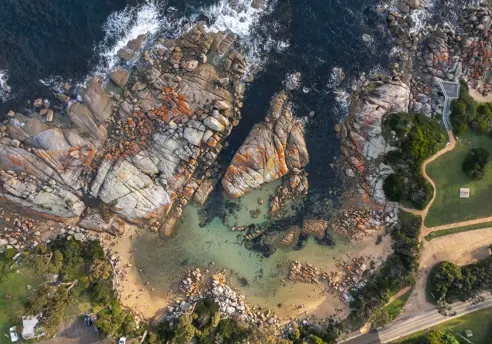 Aerial view of a sandy cove and granite boulders at The Gardens, larapuna / Bay of Fires area, Tasmania's East Coast