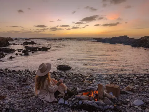 A person on a beach beside a campfire on King Island, Tasmania