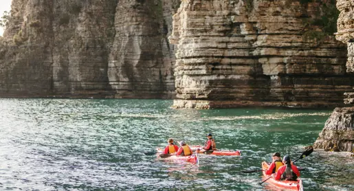 Kayakers paddling beneath tall cliffs with Southern Sea Ventures, Tasman National Park on Turrakana / Tasman Peninsula