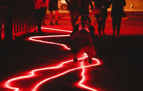 Man taking a photo of red lights on a street